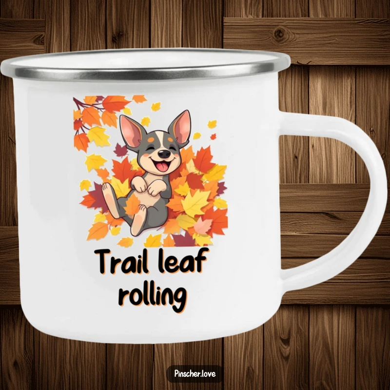 Funny Pinscher camping mug showing a joyful Pinscher dog rolling in a vibrant pile of autumn leaves, perfect for outdoor lovers.