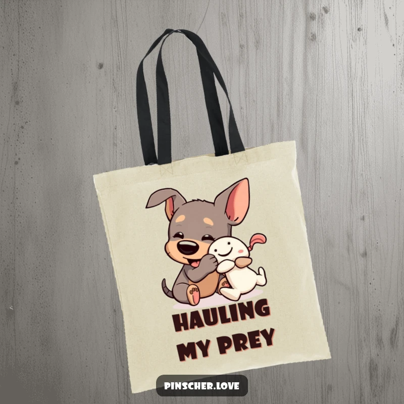 Funny Pinscher Tote Bag: A dog playfully wrestles a squeaky toy, depicting energetic and humorous canine playtime.